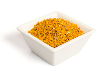 Bee pollen in the bowl closeup isolated on white background