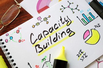 Capacity Building written in a notepad with marker.