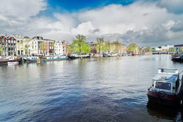 embankment of Amstel canal with traditional houses in Amsterdam, Netherlands