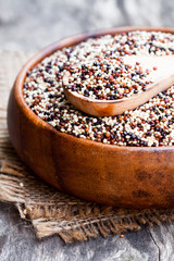 close  up of a wooden bowl with quinoa seeds on a old table