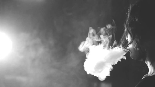she blows smoke on a background of chains, black and white
