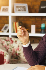 Young man holding a pencil, writing on a paper in the diary