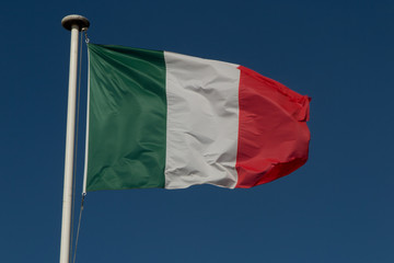 Italian flag fluttering in the wind, with blue sky. Green, White, Red and Azure are Italian national colors.