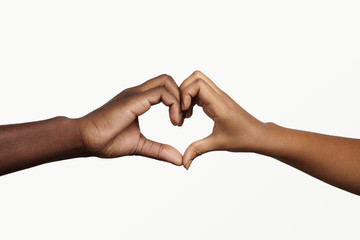 Two young dark-skinned people holding hands in shape of heart, symbolizing love, peace and unity....