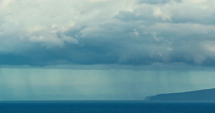 Beautiful landscape seascape view of rain clouds over island in the ocean