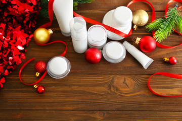 Beauty cosmetic products with Christmas decoration on wooden background