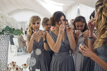 The smilling bridesmaids  stand near wedding table