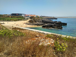 Coastline with beach and buildings near Cabo Carvoeiro in daylight, Peniche