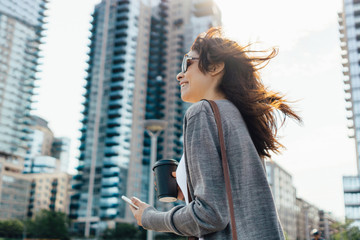Young Woman On the Mobile Phone Holding a Coffee . New York City