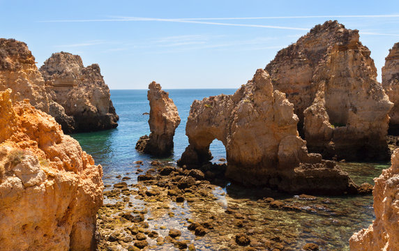 Rock cliff arches on coastline with turquoise sea water on coast of Portugal in Algarve