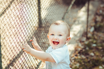 Portrait of blonde little boy posing outside