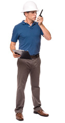 Full-length engineer architect supervisor foreman in blue polo shirt and hard hat talking into walkie talkie handheld Radio isolated on white background