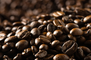 Sea of dark roasted coffee beans flowing into background