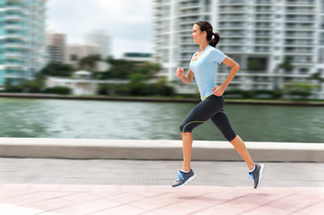 Young woman running jogging near water in downtown Miami