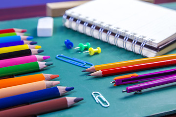 School supplies and accessory on green school table.