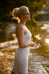Sun shines over a pretty woman walking in a river