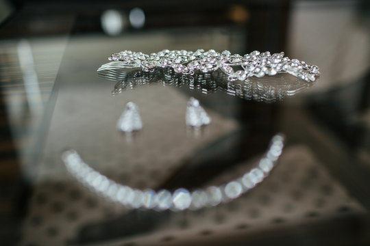 Necklace and earrings lie in a form of smile on the glass table