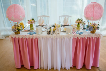 Pink newlyweds table decorated with ballons and little bouquets