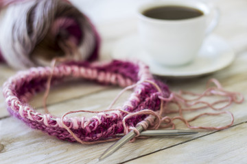 Skeins of wool and knitting needles on wooden background