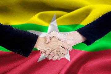 Cooperation handshake with flag of Myanmar