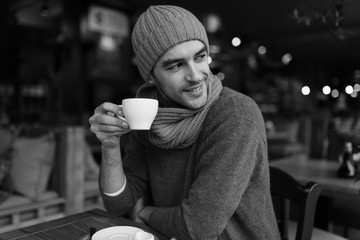 Image of handsome young man enjoying coffee in restaurant