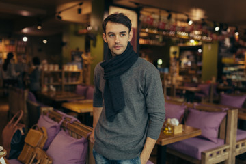 Young handsome man standing and posing in the restaurant