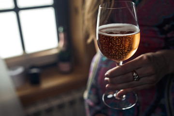 Glass with champagne held in delicate woman's hand