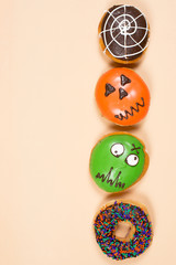 halloween sprinkles, green zombie, pumpkin, spider web set of halloween donuts background.

