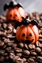 Halloween pumpkin decoration with coffee beans on dark background