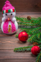Snowman, Christmas tree branch on a wooden background