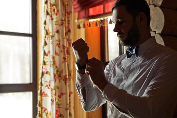 Handsome man puts a watch on his wirst