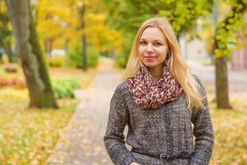 Obraz premium Young, beautiful, gentle woman walking in the park in autumn day when leaves become colorful.