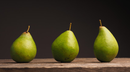Fototapeta na wymiar Three organic pears on wood