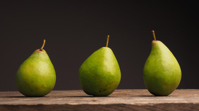 Three organic pears on wood