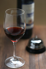 Service bell and red wine on the table