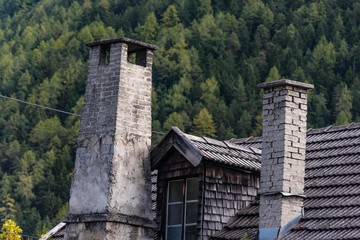 Fototapeta premium Gemauerte Schornsteine und Dachgaube mit Holzschindeln