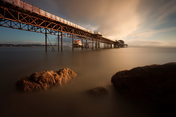 Sunrise at Mumbles Pier showing the old and new lifeboat stations, Swansea