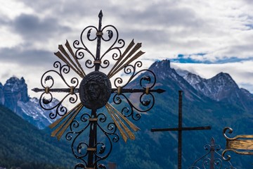 Schmiedeeisernes Grabkreuz im Stubaital mit Bergen im Hintergrund