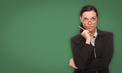 Serious Young Woman with Pencil and Glasses In Front of Blank Chalk Board.