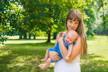 Beautiful mother and her baby playing in park