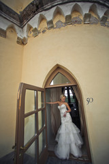 Obraz na płótnie Canvas Bride in the wedding dress in the doorway