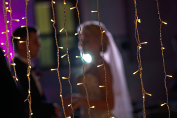 Many lights and newlyweds behind