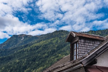 Fototapeta na wymiar Dachgaube mit Holzschindeln verkleidet, Berge im Hintergrund, Stubaital