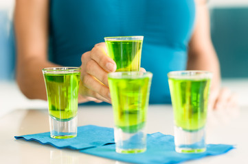 Woman Holding Green Shot Glass Close Up