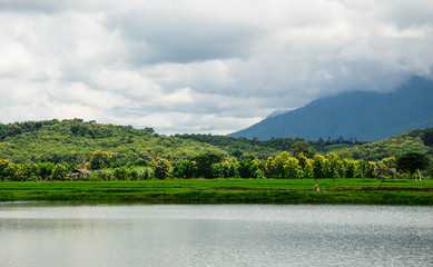 A countryside scene of a farm by the lake