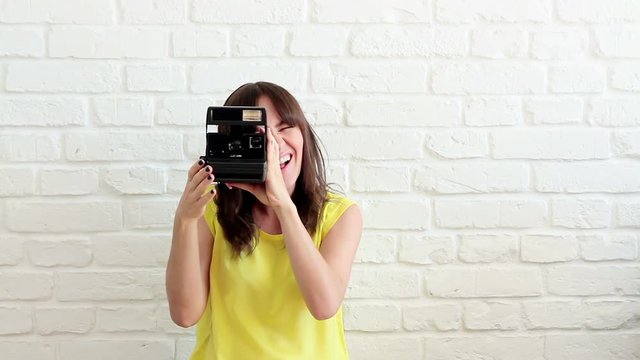 Beautiful woman taking a picture with instant camera
