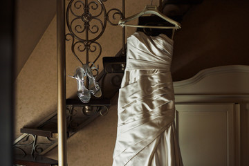 The wedding shoes and dress hang on the stairs