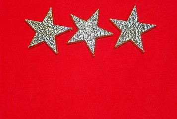 Fototapeta na wymiar Three golden stars on red background 