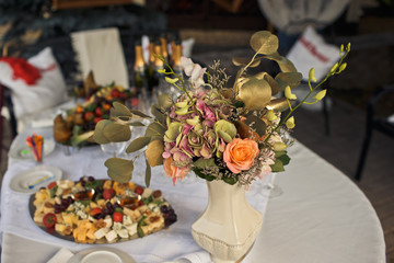 The vase with flowers stands on the bonquet table