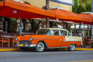 Vintage orange car parked at Ocean Drive in Miami Beach, Florida